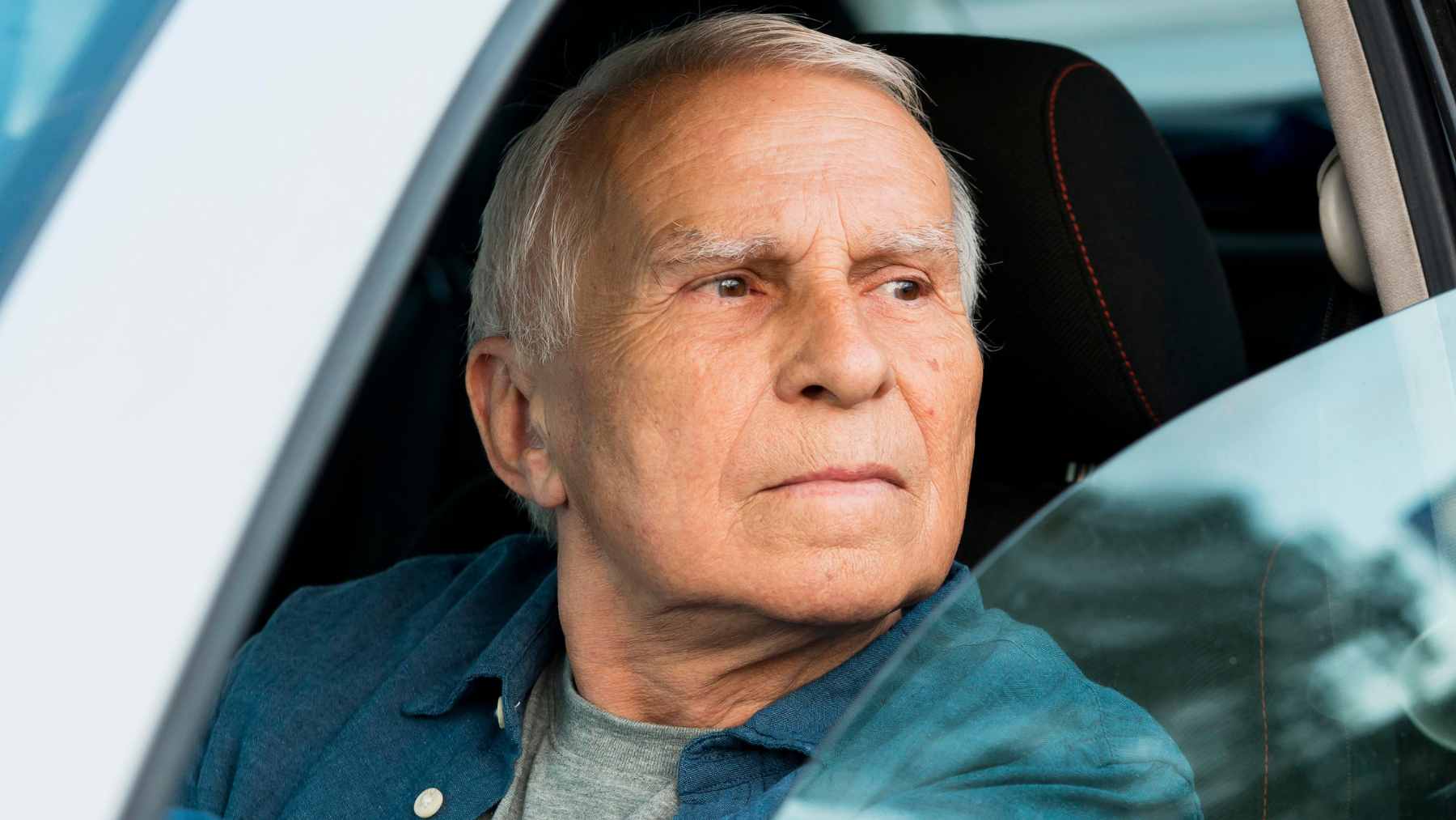 An elderly driver in Virginia preparing for an in-person DMV vision screening for a five-year license renewal.