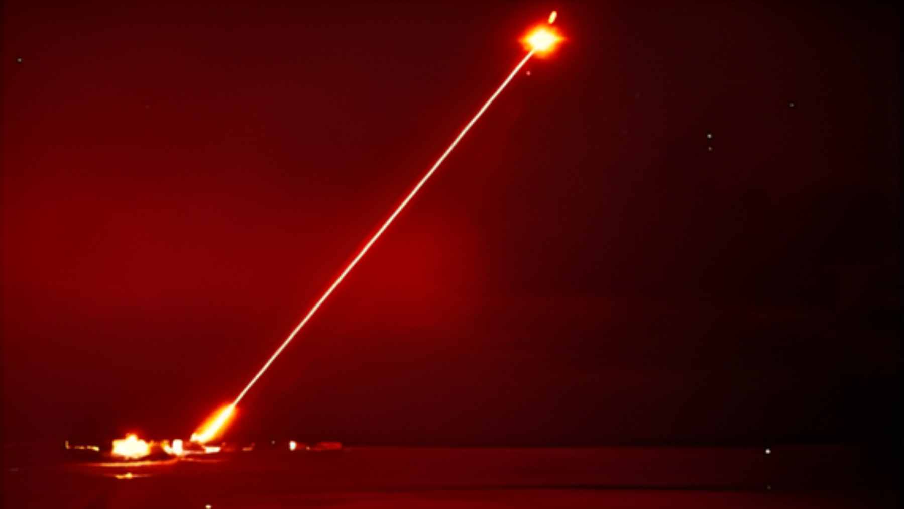 A high-energy DragonFire laser weapon system firing a concentrated beam during military trials at the Hebrides Range.