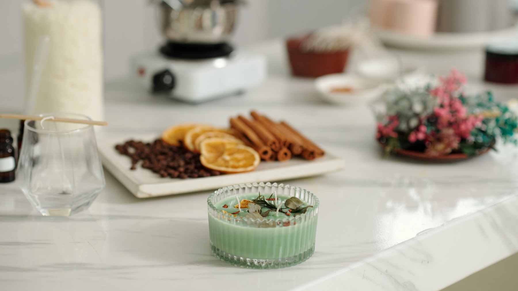 A decorative glass jar containing a homemade purple scented gel air freshener with dried lavender sprigs inside.