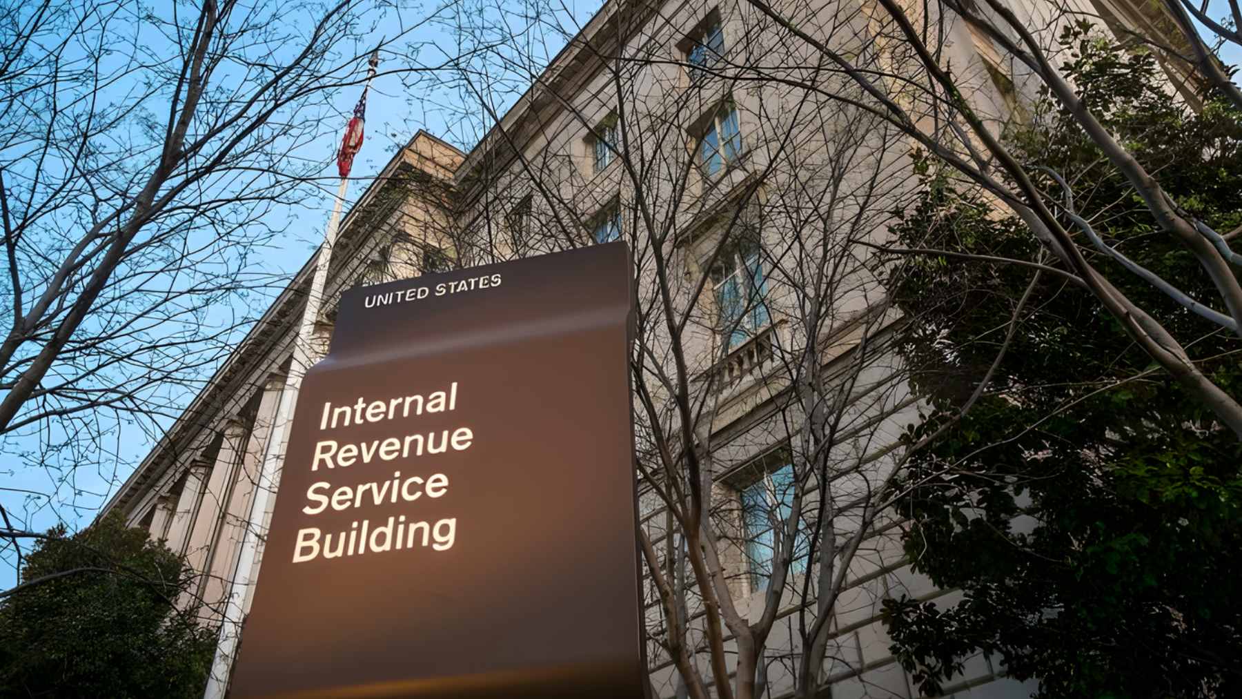 A close-up of a bank account statement showing a "frozen" status next to a pile of IRS tax notices.