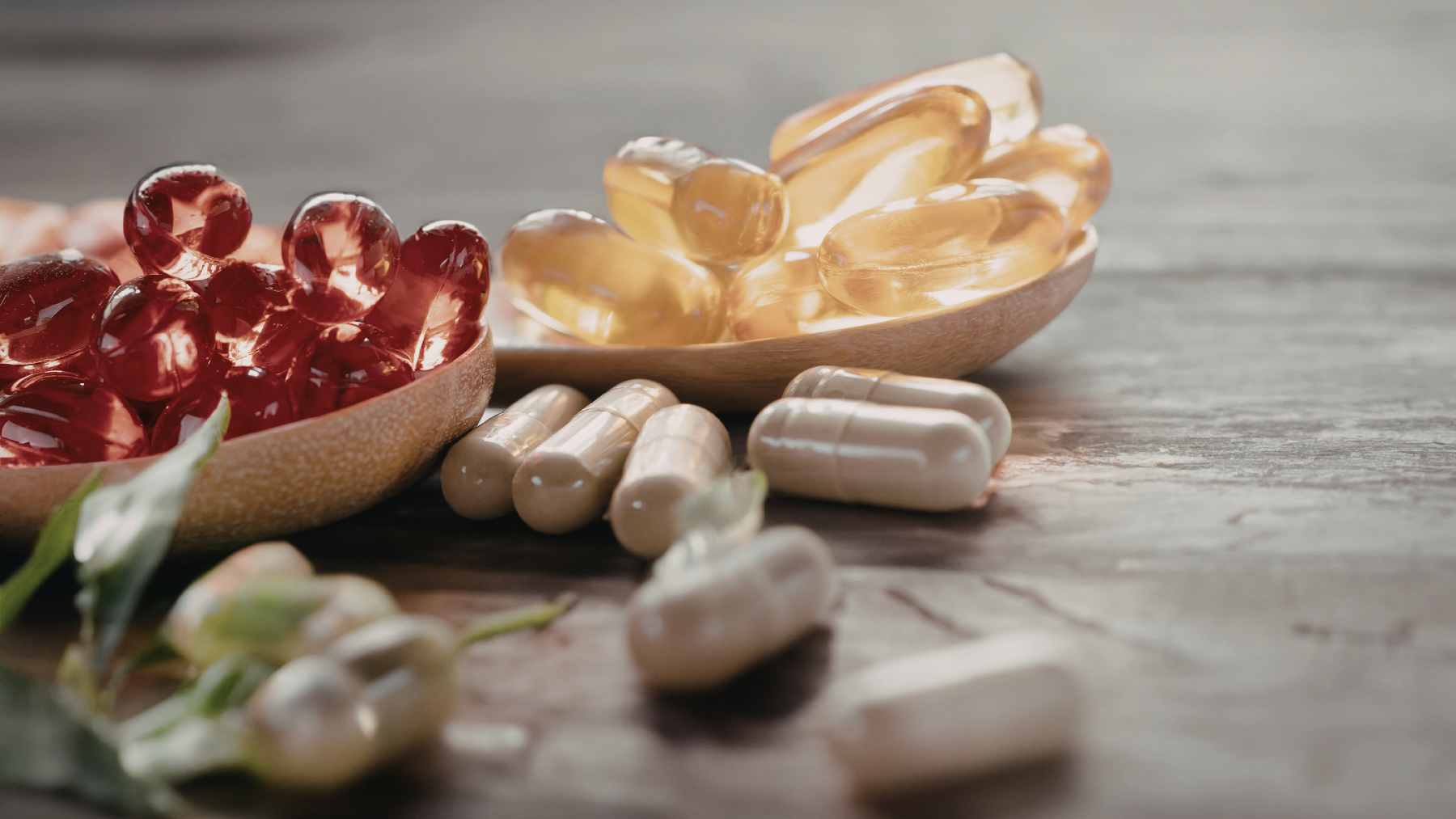 A bottle of magnesium citrate capsules next to a glass of water and a bowl of magnesium-rich spinach and almonds.