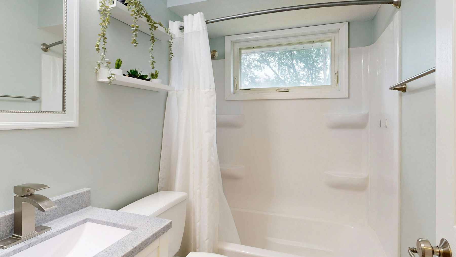A minimalist modern bathroom featuring a single fixed glass shower panel and a walk-in floor design.