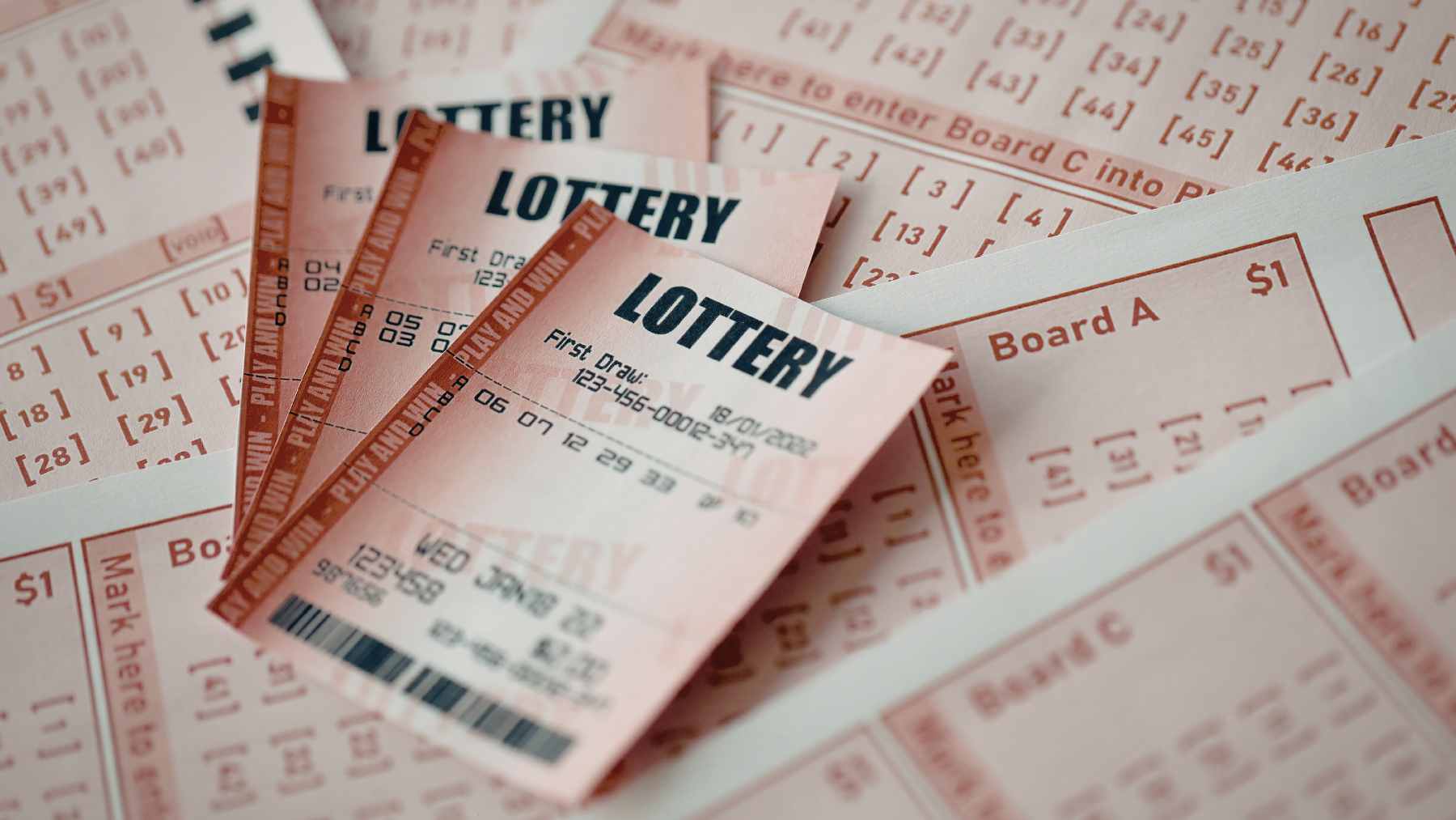 A close-up of a North Carolina Mega Millions lottery ticket held by a man in front of a lottery claim office.