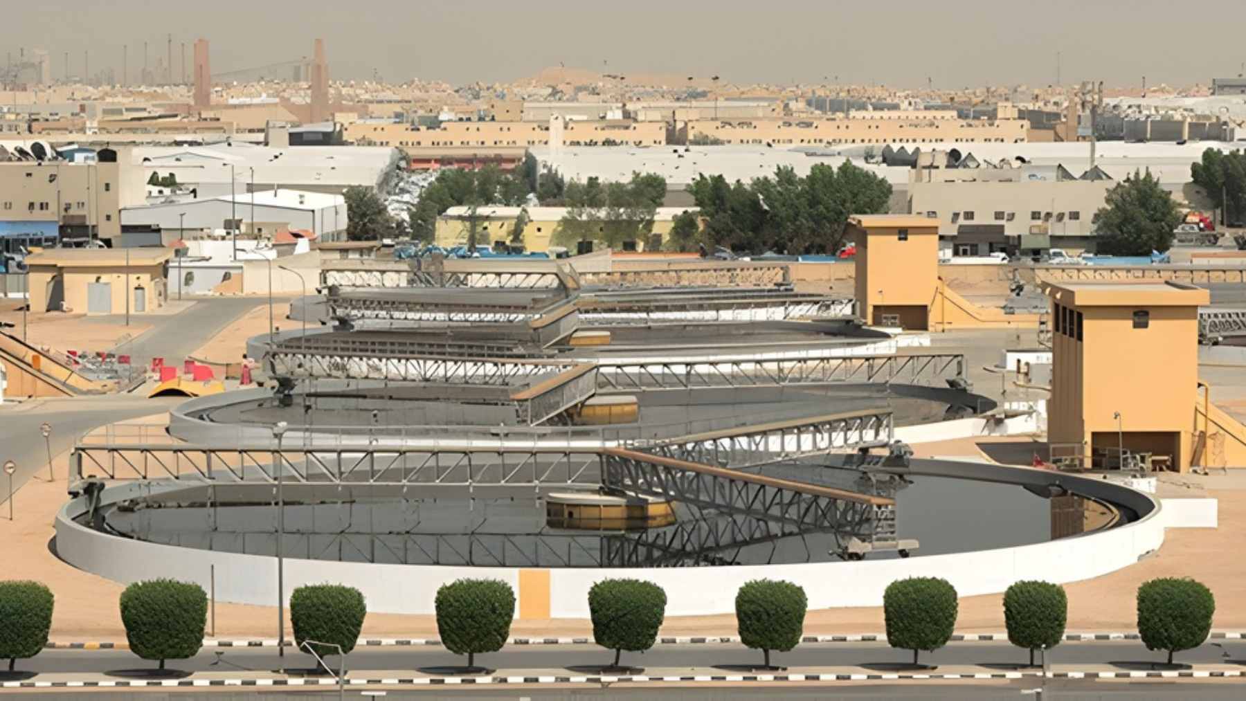 An aerial view of a 100km long artificial river flowing through the Saudi Arabian desert, surrounded by a green corridor of vegetation.