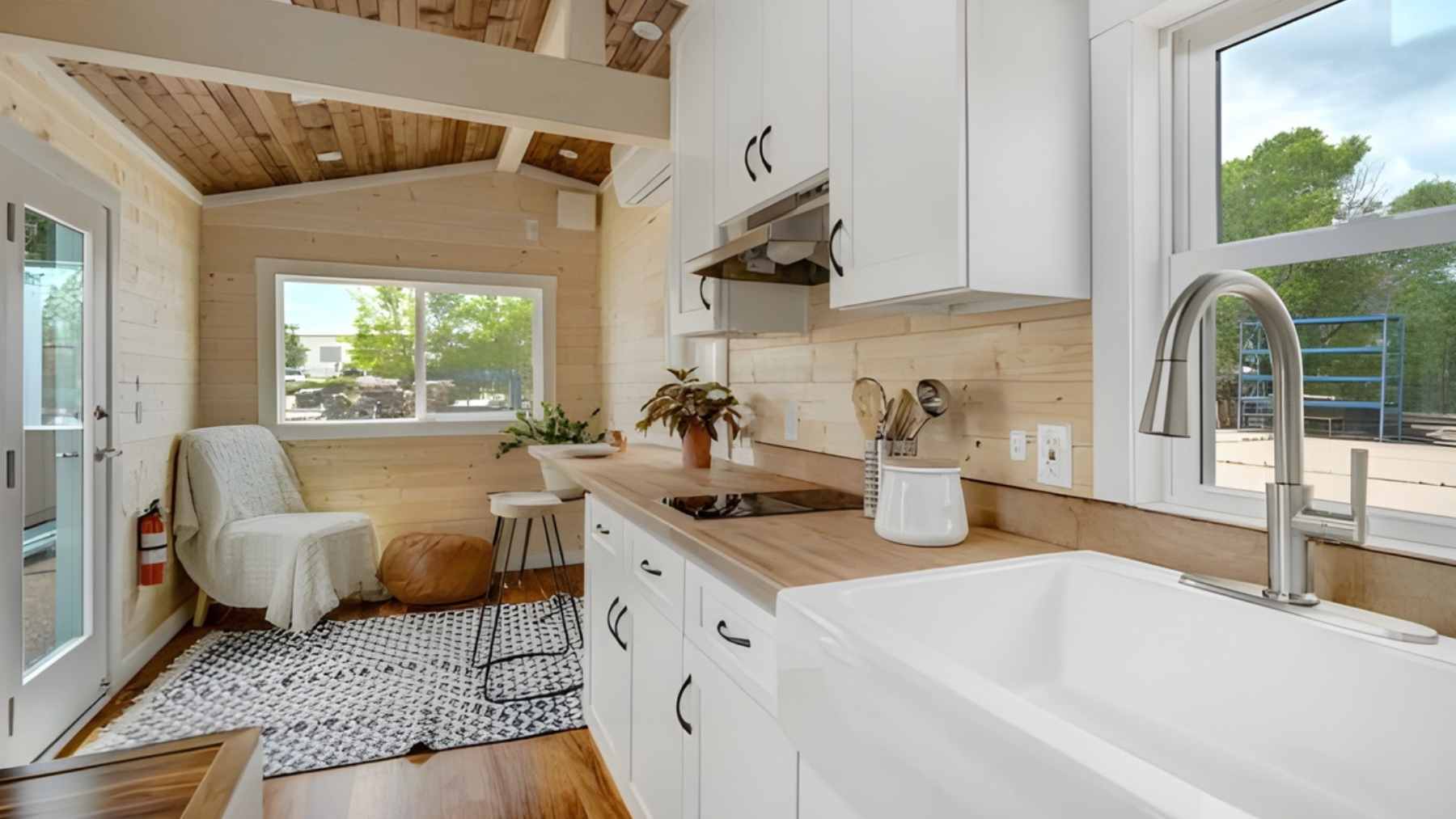 A woman looking out the window of a compact, 26 square meter tiny home, reflecting on the lack of social space.