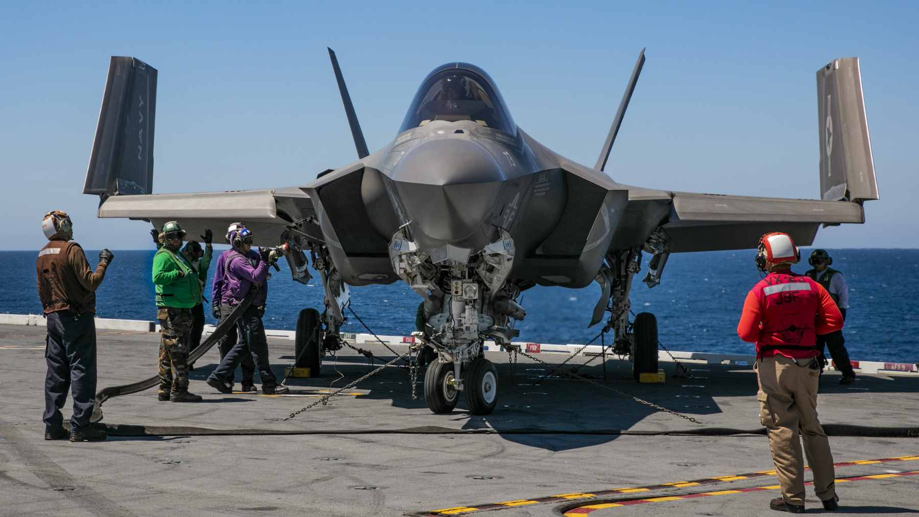 A Lockheed Martin F-35 Lightning II fighter jet flying alongside a Canadian CF-18 Hornet during a NORAD patrol exercise over the snow-covered Arctic.