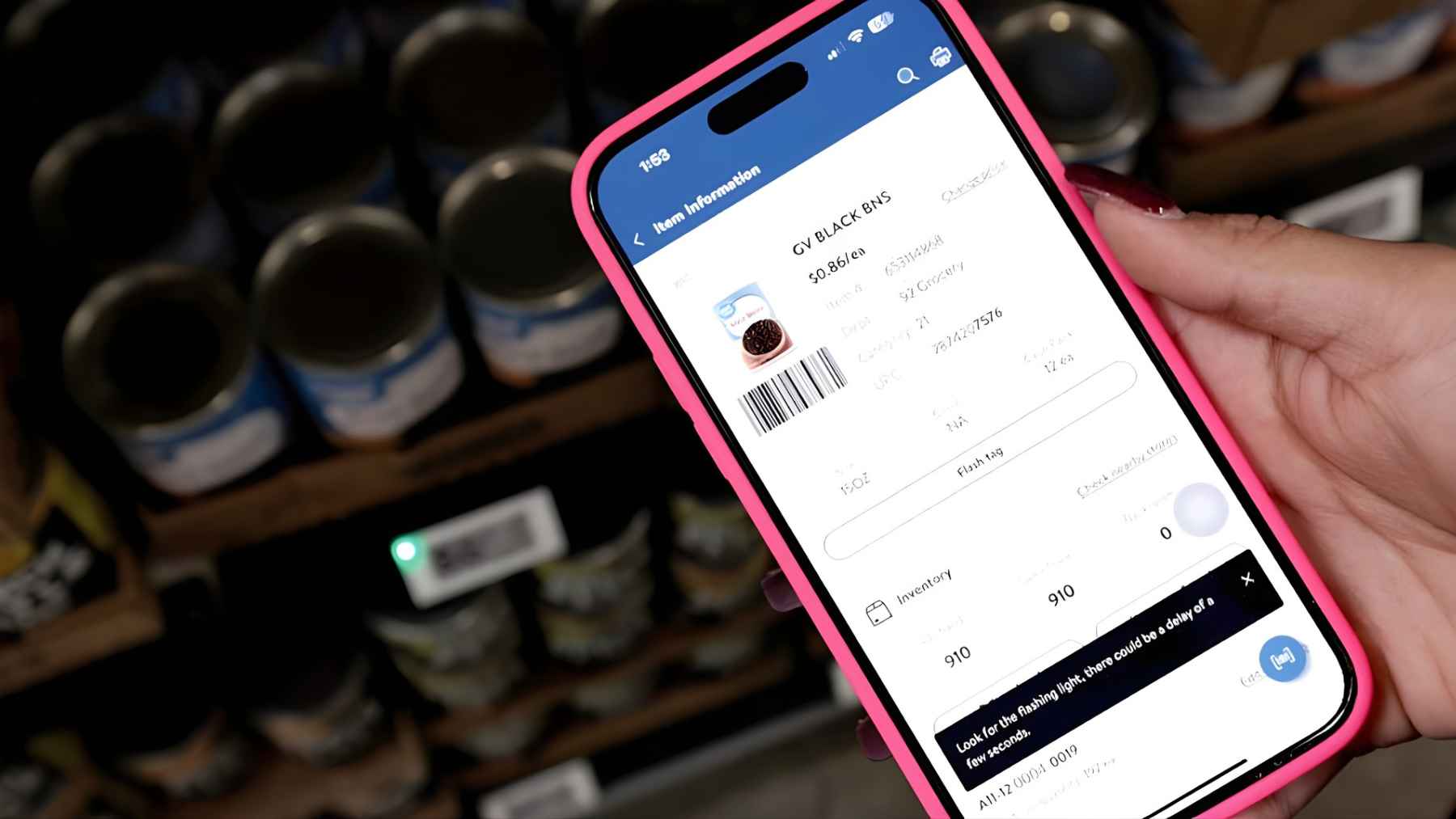 A shopper holds a smartphone showing a Walmart inventory and price screen, part of the rollout of digital shelf labels and app-based checkout.