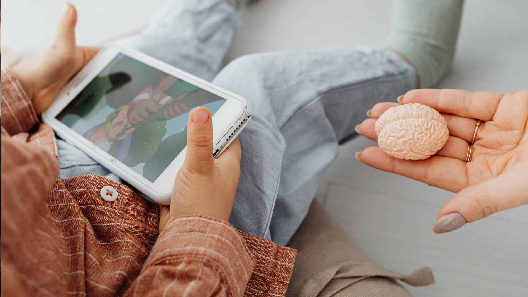 A young child looking at a smartphone screen, illustrating the focus of the Singapore GUSTO brain development study.