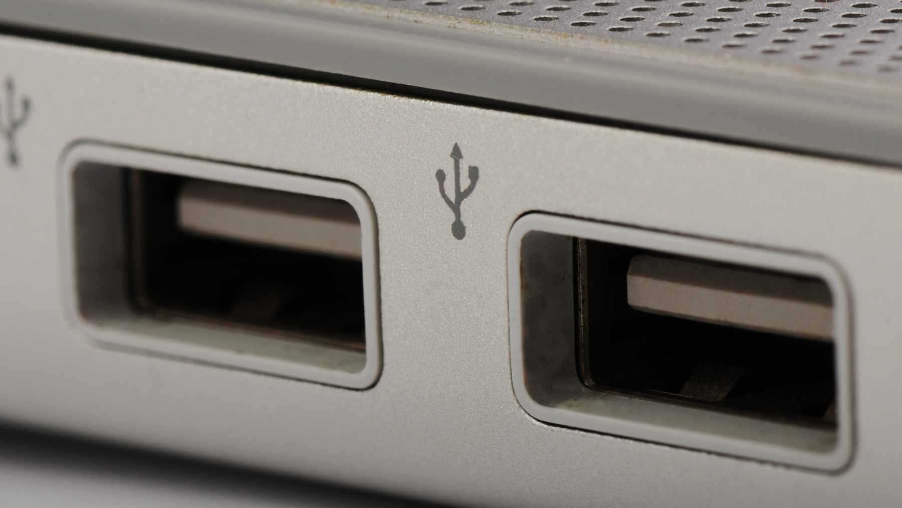 A close-up view of a laptop's side profile featuring a yellow USB Type-A port alongside standard ports.
